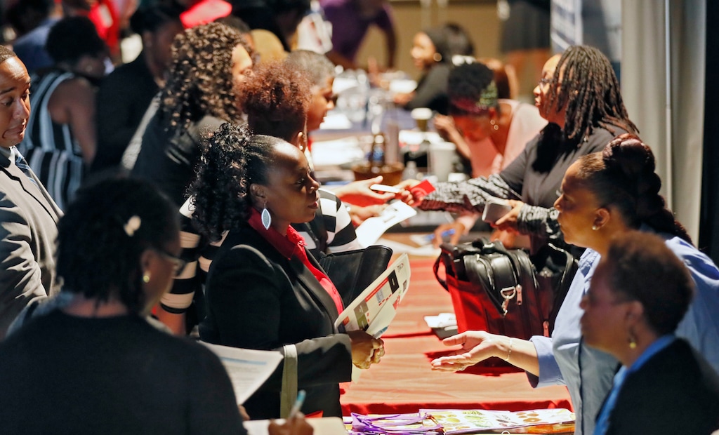 (Bob Andres | Atlanta Journal-Constitution via AP, file) Company representatives from Verizon, Goodwill, Kaiser Permanente and UPS, right, talk with potential applicants during a job and resource fair in Atlanta, Aug. 14, 2019. On Friday, Sept. 6, the U.S. government issues the August jobs report.
