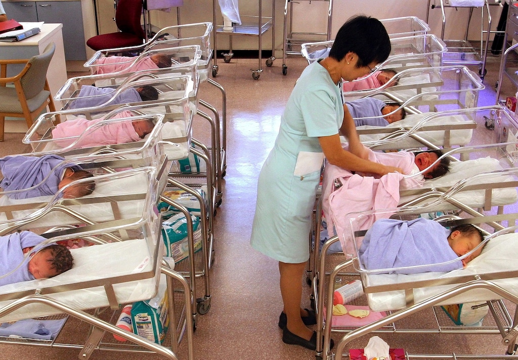 A nurse checks a newborn baby at a maternity ward at KK Women's and Children's Hospital in Singapore on February 26, 2004. (Jonathan Drake/Bloomberg)