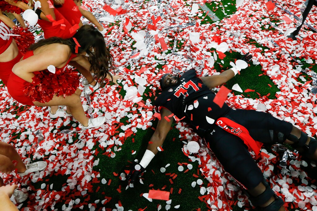 (Chase Stevens | AP) Utah offensive lineman Bamidele Olaseni lies in confetti on the field after Utah defeated Oregon 38-10 to win the Pac-12 Conference championship game in Las Vegas.