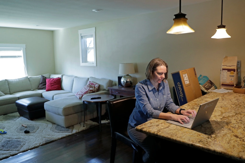 Jennifer Haller works from home, Monday, March 16, 2020, in Seattle. Earlier in the day, Haller was the first person to receive a shot of a potential vaccine for COVID-19, the disease caused by the new coronavirus, at the start of the first-stage safety study clinical trial of the vaccine at the Kaiser Permanente Washington Health Research Institute in Seattle. (AP Photo/Ted S. Warren)