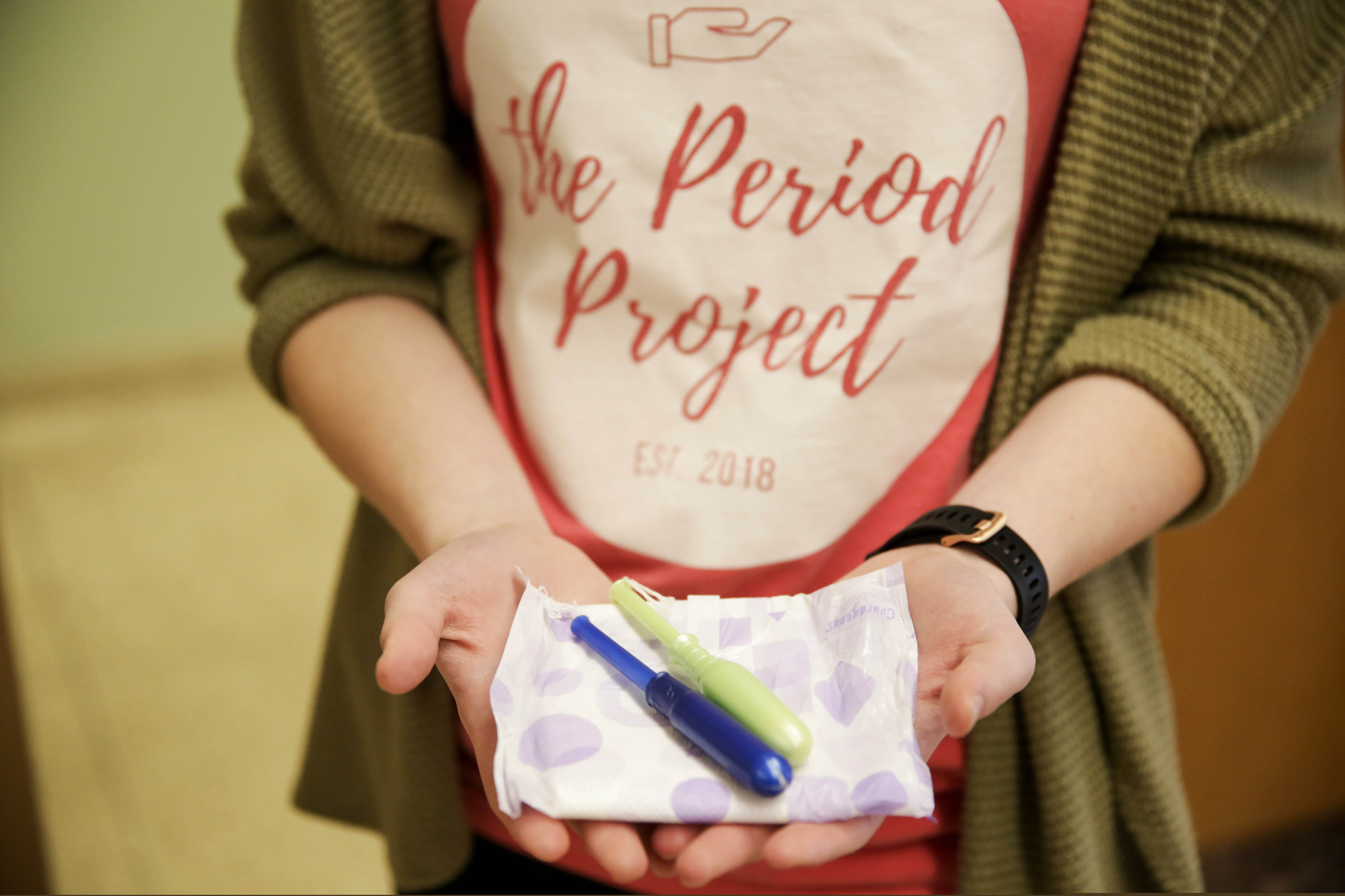 (Nikos Frazier | Journal & Courier via AP) Alison Rickert holds out an assortment of menstrual care products in Purdue University Stewart Center, Thursday, Feb. 6, 2020, in West Lafayette, Ind. Purdue University will offer free tampons and other feminine hygiene products in the campus’ bathrooms in response to student advocates who have been pushing for the move for three years.