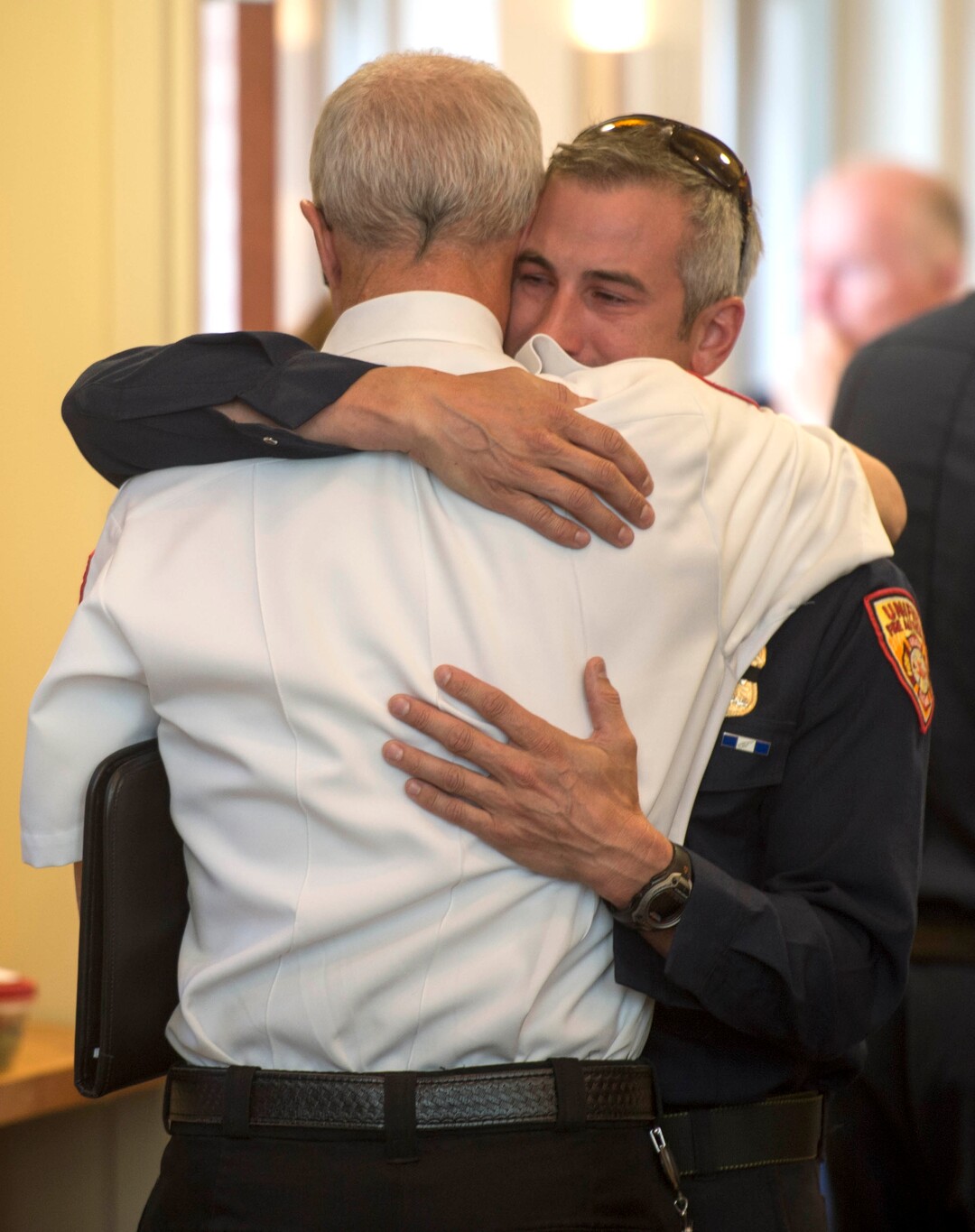 (Rick Egan  |  The Salt Lake Tribune)        Unified Fire hugs Assistant Chief Mike Watson hugs Unified Firefighter, Rob Ayres before news conference at Draper City Hall about Matt Burchett, 42, who died fighting wildfires in California. Tuesday, Aug. 14, 2018.