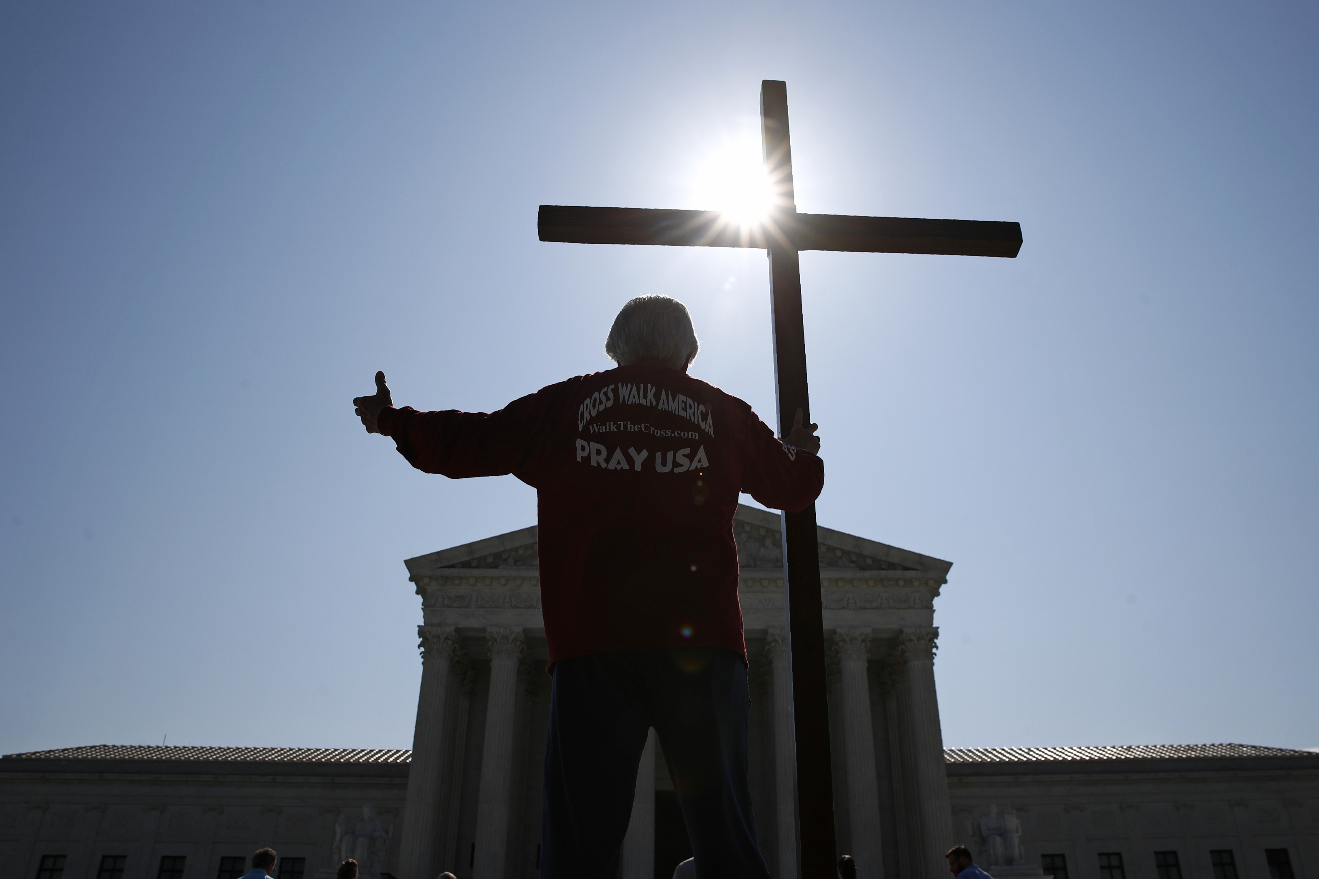 (Patrick Semansky | AP) Protester holds a cross outside the Supreme Court in 2020. Growing Christian nationalism is getting pushback in north Idaho.