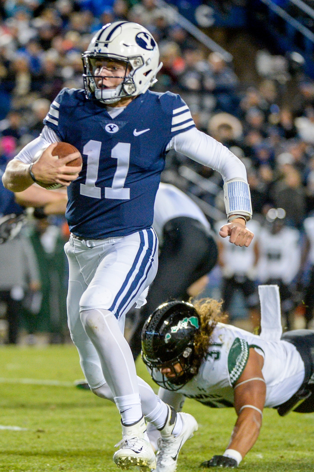 Leah Hogsten  |  The Salt Lake Tribune  Brigham Young Cougars quarterback Zach Wilson slips past Hawaii linebacker Jahlani Tavai (31) on his touchdown run as Brigham Young University hosts Hawaii at Lavell Edwards Stadium in Provo, Saturday Oct. 13, 2018. 