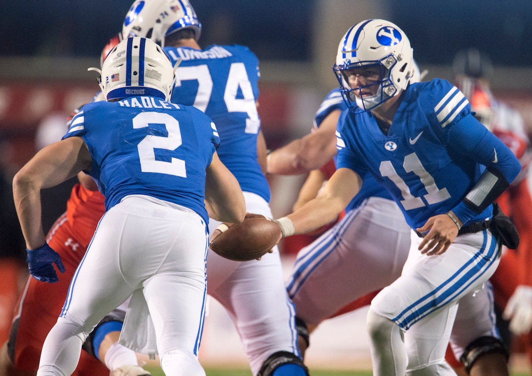 (Rick Egan  |  The Salt Lake Tribune)      Brigham Young Cougars quarterback Zach Wilson (11 hands off to Brigham Young Cougars running back Matt Hadley (2), in  football action between the Brigham Young Cougars and the Utah Utes, at Rice-Eccles Stadium, Saturday, November 24, 2018.