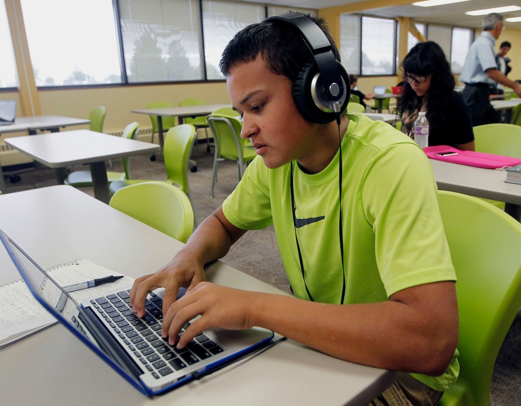 (Al Hartmann  |  Tribune file photo) A student takes notes while studying a math lesson from his laptop at Kaysville charter school Career Path High.
