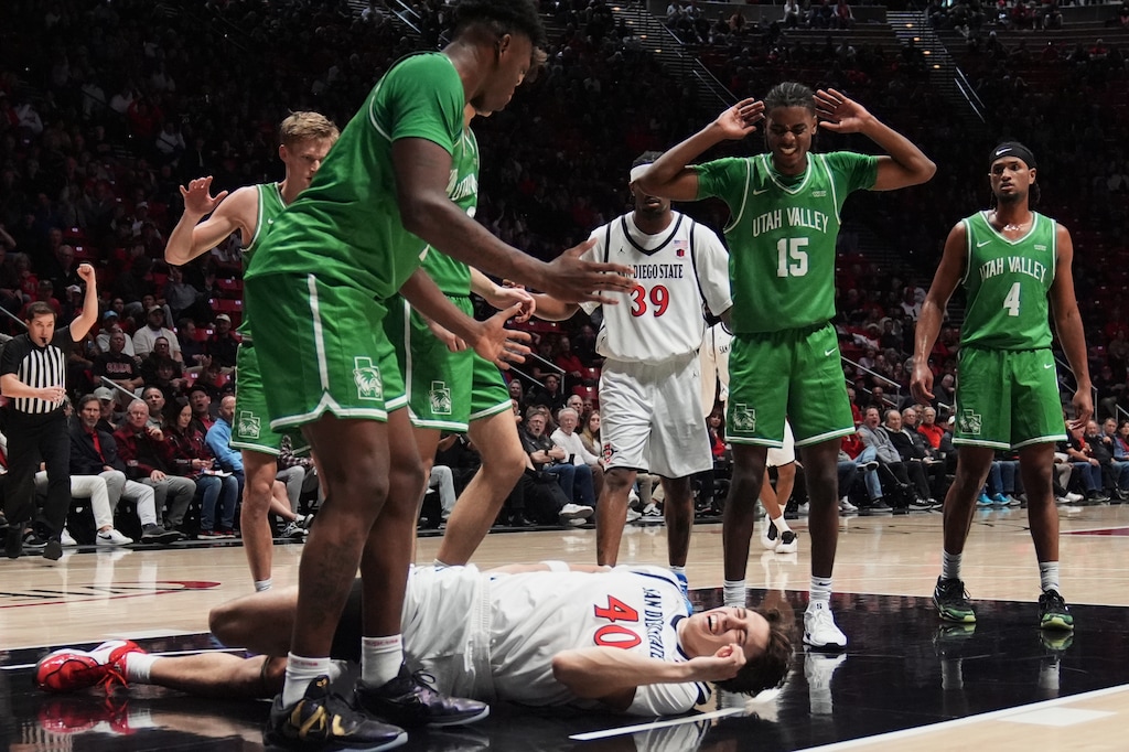 (Gregory Bull | AP) Utah Valley guard Tyler Hendricks (15) reacts as San Diego State forward Miles Heide, below, stays down after an injury during the first half of an NCAA college basketball game Wednesday, Dec. 3, 2025, in San Diego.