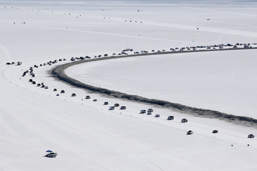 (Rick Bowmer | Associated Press) Cars form a line near the race track at the Bonneville Salt Flats near Wendover, Utah, on Aug. 13, 2016. The crust keeps tires cool at high speeds and provides an ideal surface for racing — unless seasonal flooding fails to recede or leaves behind an unstable layer of salt.