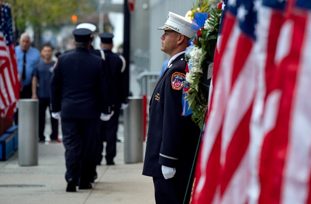 (Craig Ruttle | AP Photo) New York City firefighters take their positions in front of a memorial on the side of a firehouse adjacent to One World Trade Center and the 9/11 Memorial site during ceremonies commemorating the 18th anniversary of the 9/11 terrorist attacks in New York on Wednesday, Sept. 11, 2019.