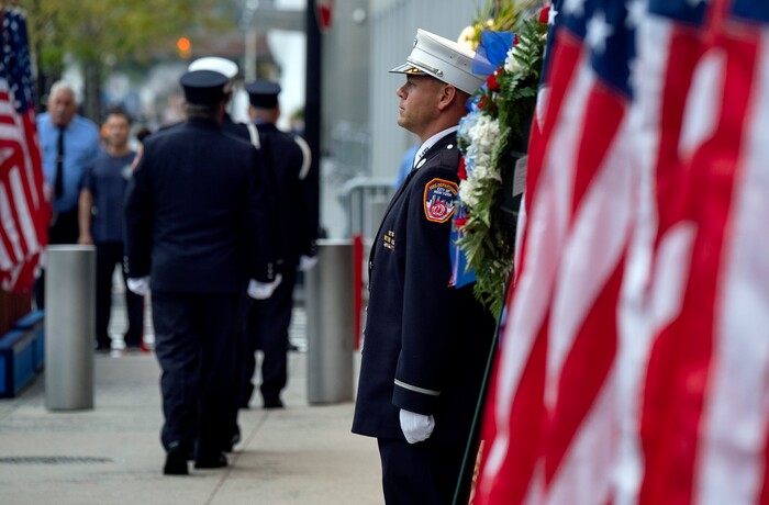 (Craig Ruttle | AP Photo) New York City firefighters take their positions in front of a memorial on the side of a firehouse adjacent to One World Trade Center and the 9/11 Memorial site during ceremonies commemorating the 18th anniversary of the 9/11 terrorist attacks in New York on Wednesday, Sept. 11, 2019.