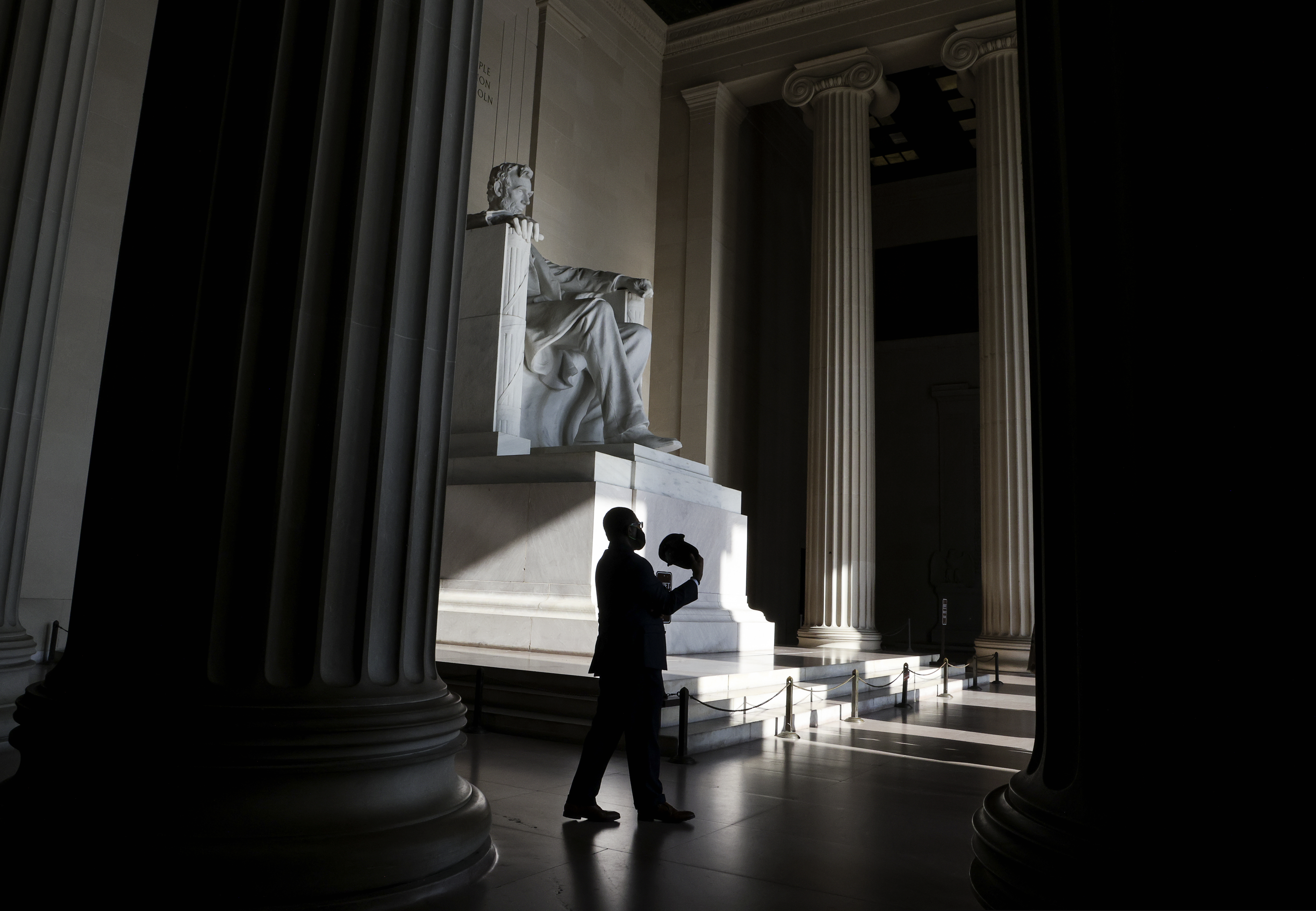A man fans himself with his hat inside the Lincoln Memorial as demonstrators gather for the March on Washington, Friday Aug. 28, 2020, at the Lincoln Memorial in Washington, on the 57th anniversary of the Rev. Martin Luther King Jr.’s “I Have A Dream” speech. (Jonathan Ernst/Pool via AP)