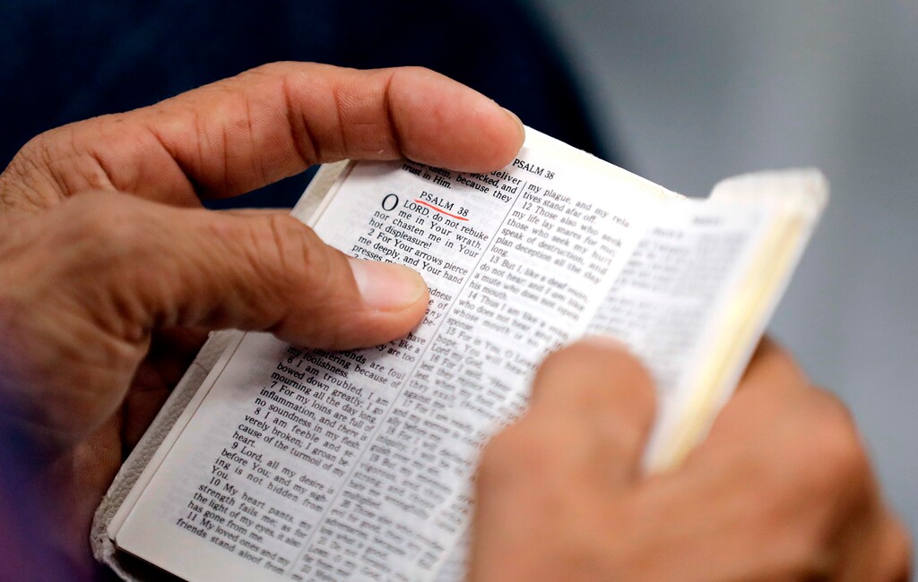 (AP Photo/David J. Phillip, File) In this Sept. 3, 2017, file photo, a man holds a Bible during service at Christ United Church in the aftermath of Hurricane Harvey in Cypress, Texas.