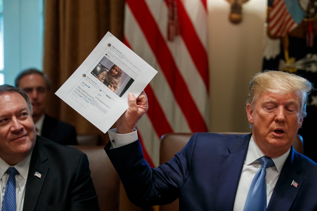 Secretary of State Mike Pompeo, left, looks at a paper held by President Donald Trump about Rep. Ilhan Omar, D-Minn., as Trump speaks during a Cabinet meeting in the Cabinet Room of the White House, Tuesday, July 16, 2019, in Washington. (AP Photo/Alex Brandon)