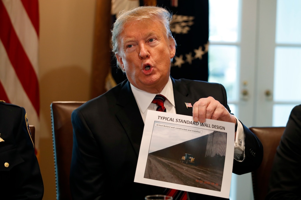 President Donald Trump holds a photo as he leads a roundtable discussion on border security with local leaders, Friday Jan. 11, 2019, in the Cabinet Room of the White House in Washington. (AP Photo/Jacquelyn Martin)