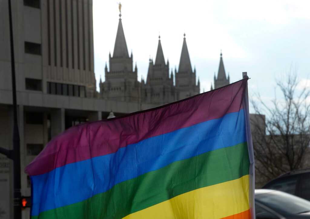 (Scott Sommerdorf   |  The Salt Lake Tribune)   A rainbow flag frames the LDS Temple from its place at the 8th annual mass resignation in City Creek Park, Sunday, November 5, 2017. 