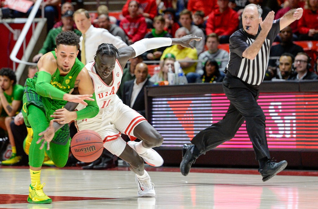 (Leah Hogsten  |  Tribune file photo) Oregon Ducks guard Anthony Mathis (32) and Utah Utes guard Both Gach (11) battle for a loose ball. The University of Utah basketball team has been pretty good at home but has struggled on the road.