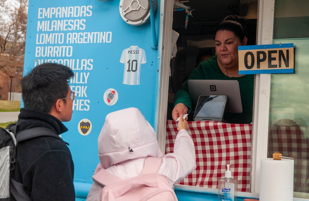 (Evelyn Harris  |  Amplify Utah) Mariana Galvan, co-owner of The Chimichurri Grill, takes an order from two students in the University of Utah's Marriott Plaza.
