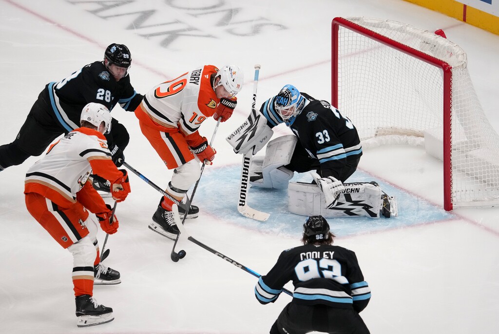 (Bethany Baker | AP) Anaheim Ducks right wing Troy Terry (19) shoots as defenseman Jackson LaCombe (2) assists while Utah Hockey Club goaltender Jaxson Stauber (33) defends with defenseman Ian Cole (28) and center Logan Cooley (92) during the second period of an NHL hockey game, Sunday, Dec. 22, 2024, in Salt Lake City.