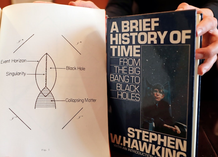 A Book, and scripts by Stephen Hawking are among the personal and academic possessions of Stephen Hawking at the auction house Christies in London, Friday, Oct. 19, 2018. The online auction announced Monday Oct. 22, 2018, by auctioneer Christie’s features 22 items from Hawking, including his doctoral thesis on the origins of the universe, with the sale scheduled for 31 October and 8 November. (AP Photo/Frank Augstein)