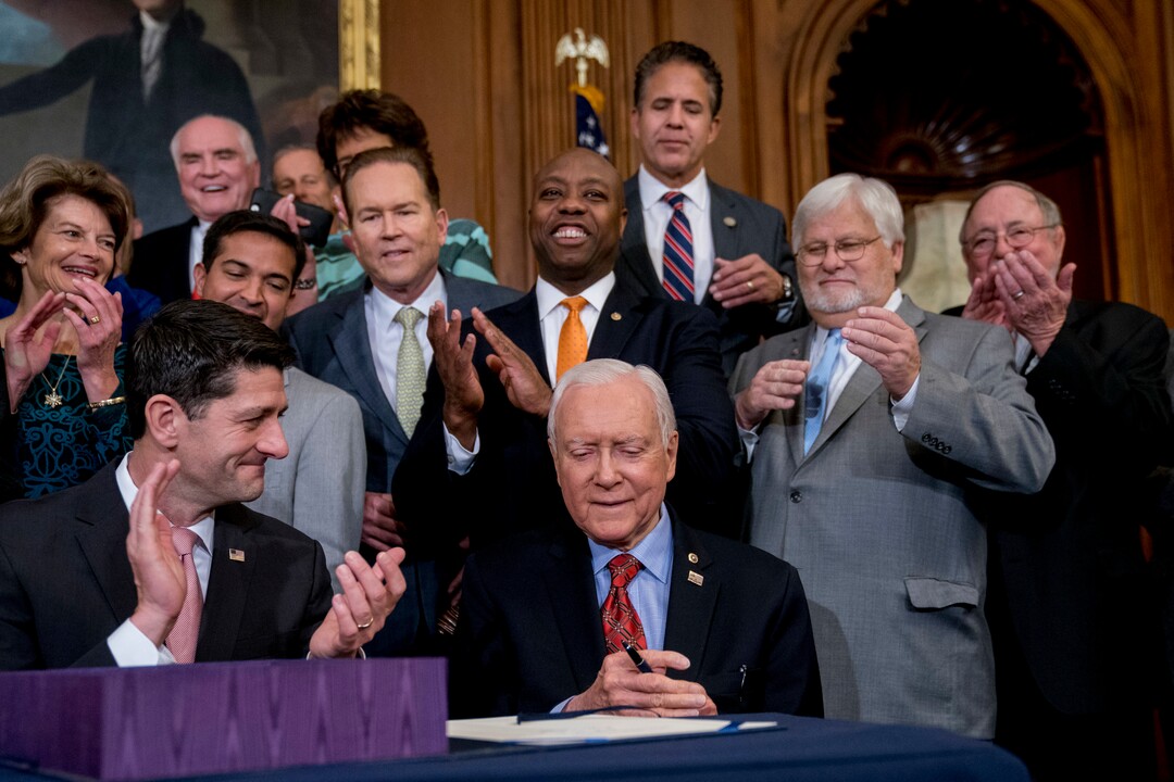(Andrew Harnik  AP Photo)  Speaker of the House Paul Ryan, R-Wis., bottom left, and other Republican congressmen, applaud as Senate Finance Committee Chairman Orrin Hatch, R-Utah, seated at center, signs the final version of the GOP tax bill during an enrollment ceremony at the Capitol in Washington, Thursday, Dec. 21, 2017.
