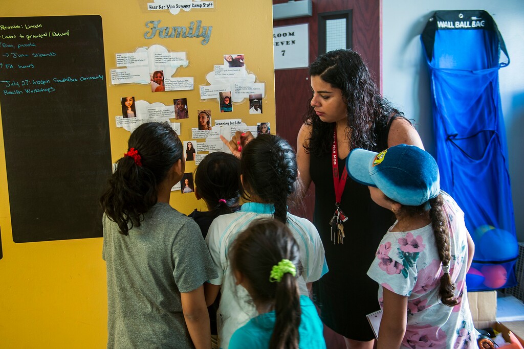 (Chris Detrick | Tribune file photo) Promise South Salt Lake Site Coordinator Susie Estrada shows children pictures of the staff members at the Hser Ner Moo Community Center in South Salt Lake City Tuesday, July 18, 2017. The Promise before and after-school program has new leadership, amid an audit into South Salt Lake City funding that began back in June.