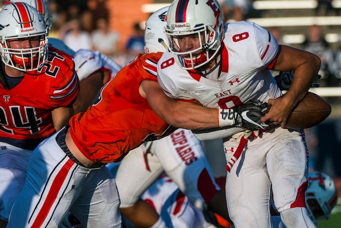 (Chris Detrick  |  The Salt Lake Tribune)  East's Ben Ford (8) is tackled by Timpview's Jacob Bosco (15) during the game at Timpview High School Thursday, August 17, 2017. 