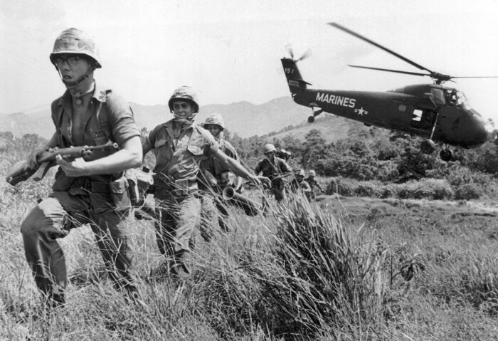 FILE - In this April 28, 1965 file photo, U.S. Marine infantry stream into a suspected Viet Cong village near Da Nang in Vietnam during the Vietnamese war. Filmmaker Ken Burns said he hopes his 10-part documentary about the War, which begins Sept. 17, 2017 on PBS, could serve as sort of a vaccine against some problems that took root during the conflict, such as a lack of civil discourse in America. (AP Photo/Eddie Adams, File)