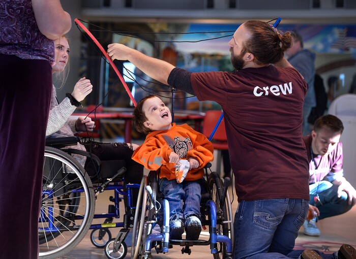 (Scott Sommerdorf | The Salt Lake Tribune)
Three year old Drew Cheever watches as volunteers Shriners Hospitals for Children volunteers Landon DeGarmo, right, and Taylor Cutler, left help transform his wheelchair into a Spiderman-themed chair with webs, ready for Halloween, Wednesday, October 18, 2017.