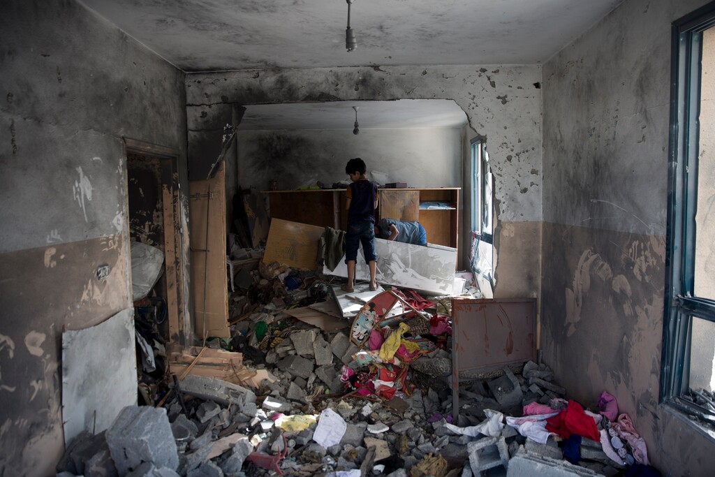 (Khalil Hamra | The Associated Press)  Palestinians inspect a damaged bedroom following a late night Israeli missile strike on a building in town of Beit Lahiya, Northern Gaza Strip, on Monday, May 6, 2019. The Israeli military has lifted protective restrictions on residents in southern Israel while Gaza's ruling Hamas militant group reported a cease-fire deal had been reached to end the deadliest fighting between the two sides since a 2014 war.