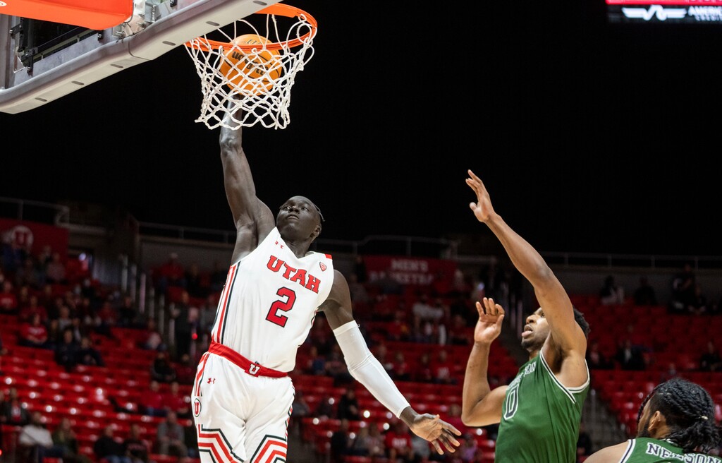 (Rick Egan | The Salt Lake Tribune) Utah Utes guard Both Gach (2) dunks the ball, as Manhattan Jaspers forward Warren Williams (0) defends, in basketball action between the Utah Utes and the Manhattan Jaspers at the Jon M.Huntsman Center, on Saturday, December 11, 2021.