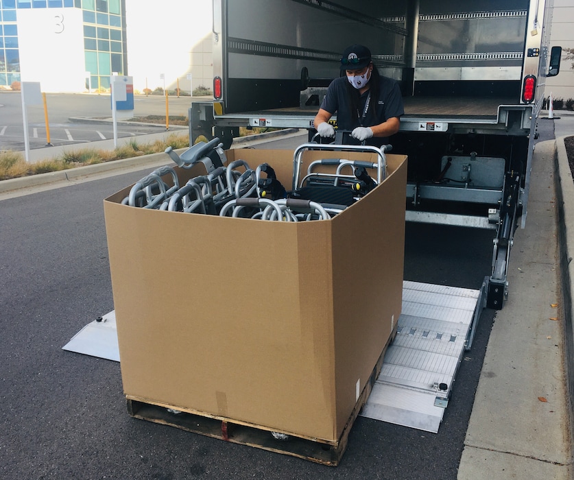 (Sean P. Means | The Salt Lake Tribune) Sebastian Smith, a courier for Intermountain Medical Center in Murray, moves a pallet box filled with donated walkers into a truck on Saturday, Oct. 30, 2021. IMC was one of 11 hospitals in Utah taking donated walkers, crutches, canes and non-motorized wheelchairs in a program called LeanOn Utah.
