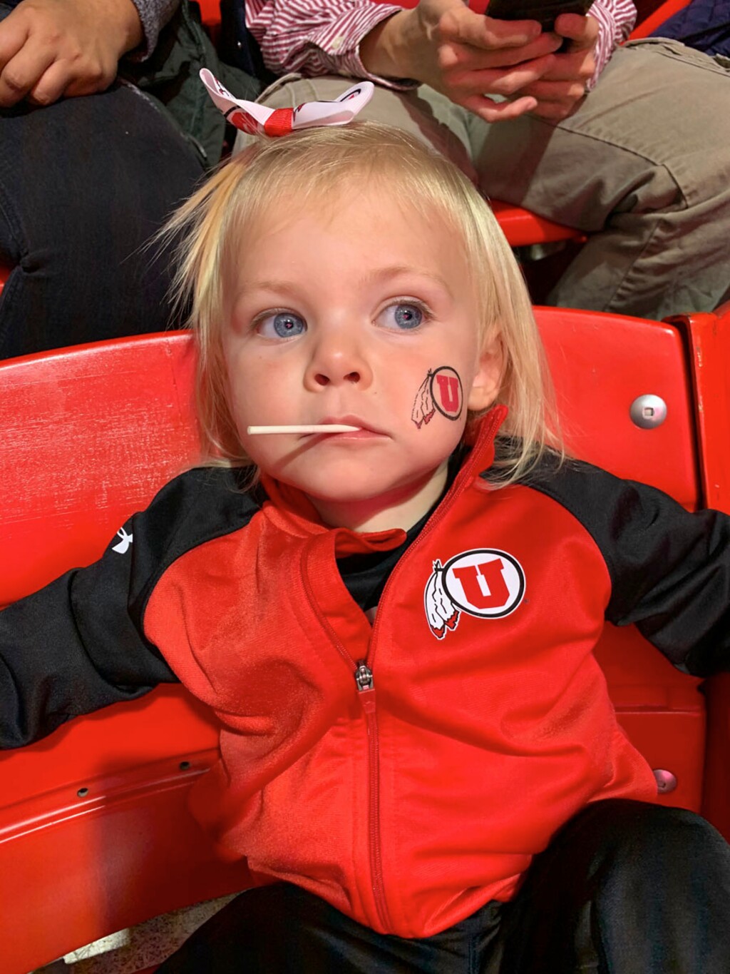 (Photo courtesy of Don Gale) Ella, a great-granddaughter of Don Gale, sits bewildered at the chaos of a University of Utah basketball game.