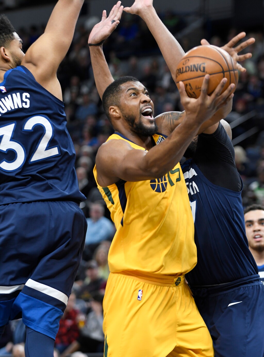 Utah Jazz's Derrick Favors, center, goes to the basket between Minnesota Timberwolves' Karl-Anthony Towns, left, and Taj Gibson, right, in the first quarter of an NBA basketball game Sunday, April. 1, 2018, in Minneapolis. (AP Photo/Tom Olmscheid)