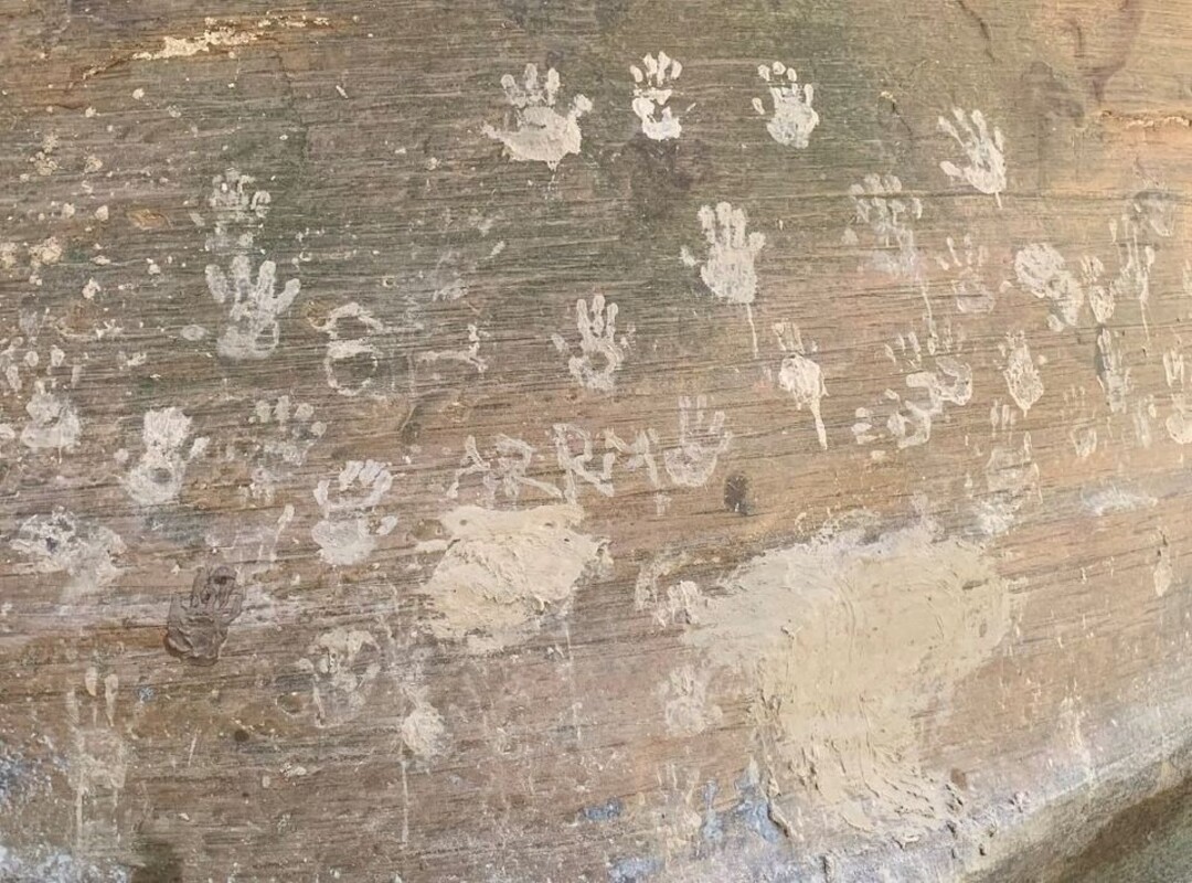 (Photo courtesy of the National Park Service) Muddy hand prints intentionally left on a sandstone rock at Zion National Park.