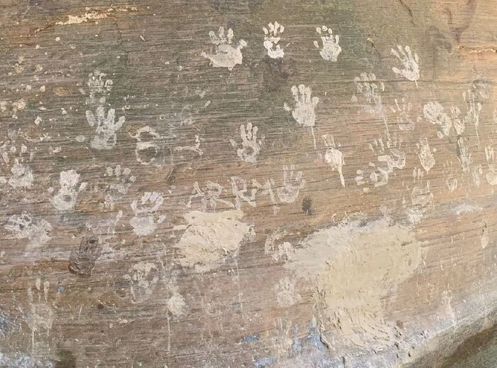 (Photo courtesy of the National Park Service) Muddy hand prints intentionally left on a sandstone rock at Zion National Park.