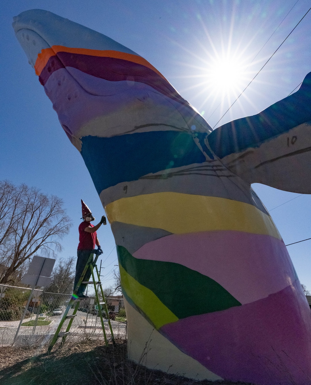 (Francisco Kjolseth | The Salt Lake Tribune) Local artist Mike Murdock begins his colorful transformation of “Out of the Blue,” by artist Stephen Kesler on Thursday, April 7, 2022. Murdock, who remains neutral on the topic of gnomes vs whales, pays tribute to the packs of gnomes that once ruled the now-infamous roundabout.