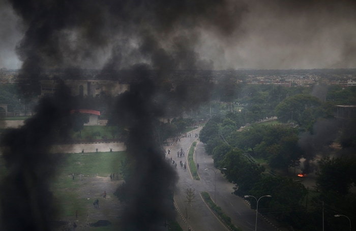 Smoke billows after supporters of the Dera Sacha Sauda sect set vehicles on fire near in Panchkula, India, Friday, Aug. 25, 2017.  Deadly riots have broken out in a north Indian town after a court convicted a guru of raping two of his followers. Mobs also attacked journalists and set fire to government buildings and railway stations. (AP Photo/Altaf Qadri)