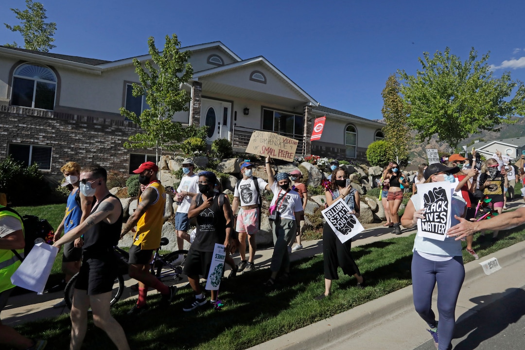 Protesters march Sunday, Aug. 2, 2020, in Cottonwood Heights, Utah. The protest was a "March for Justice" focused largely around Zane James, who was fatally shot by police in Cottonwood Heights in 2018. (AP Photo/Rick Bowmer)