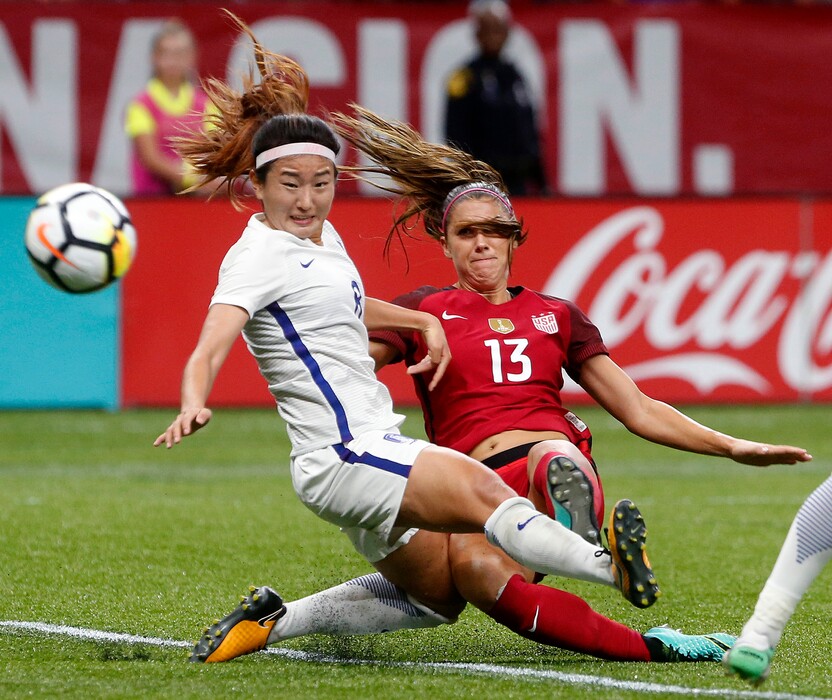 U.S. forward Alex Morgan (13) scores a goal as South Korea midfielder Cho Sohyun defends during the first half of an international friendly soccer match in New Orleans, Thursday, Oct. 19, 2017. (AP Photo/Gerald Herbert)