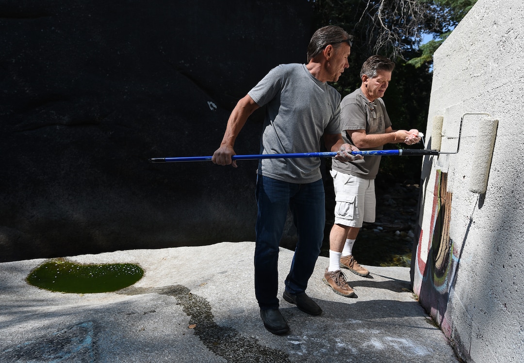 (Francisco Kjolseth  |  The Salt Lake Tribune)  Scott Whipperman, left, and Michael Nebeker cover up graffiti that has proliferated in lower Little Cottonwood Canyon, where vandals, often wielding cans of fluorescent-colored spray paint, have covered granite faces, trees and structures. The vandalism is particularly apparent along the Temple Quarry Trail and the creek at the Moon Rock swimming hole and former pavilion site. Volunteers using donated equipment and solvents spend thousands of hours removing the paint from the rocks only to see graffiti return to the same faces or on rock nearby.