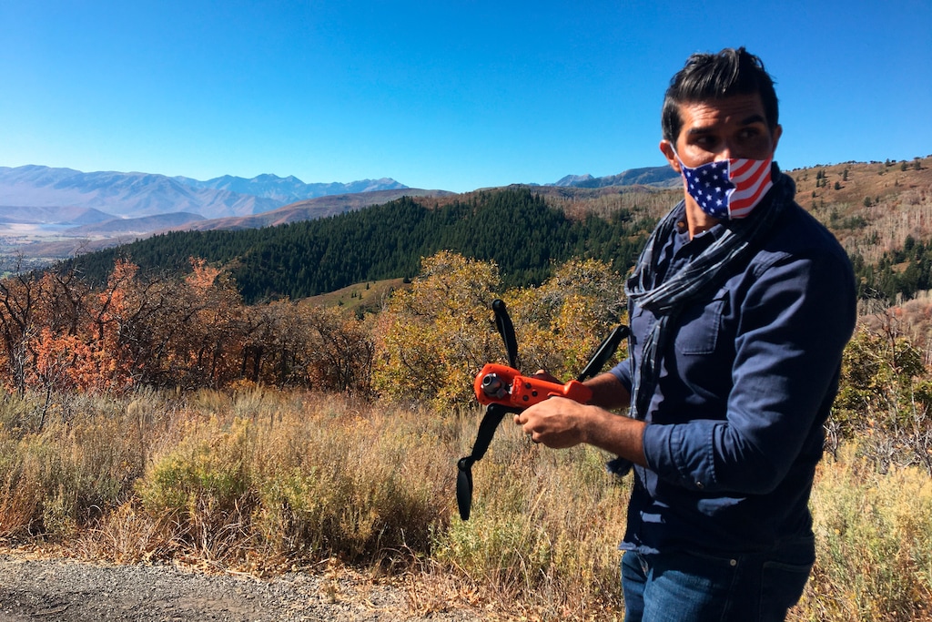 (Jon Reed | KUER-FM via AP) Jacob Narayan, 46, gets ready to fly his drone on a hilltop outside of Park City, Utah, on Sept. 30, 2020. Narayan has worked as a waiter for years, but the pandemic has made that unsustainable. Now he's shifting gears and working as a drone photographer.