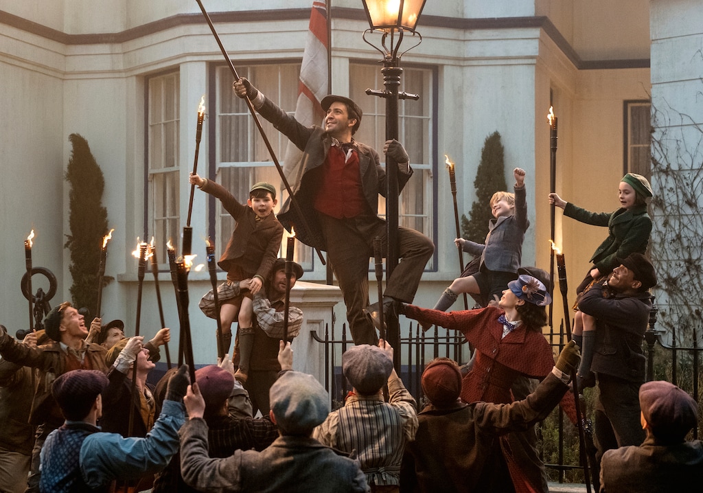 (Jay Maidment  |  courtesy Walt Disney Pictures) The lamplighter Jack (Lin-Manuel Miranda, center) leads the Banks family and Mary Poppins (Emily Blunt, lower right) in song in a scene from Disney's "Mary Poppins Returns."