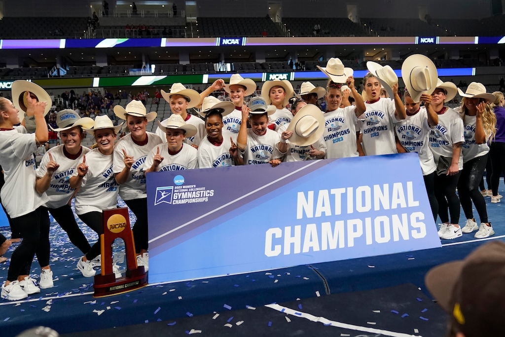 The Oklahoma team poses for photos after winning the NCAA women's gymnastics title Saturday, April 15, 2023, in Fort Worth, Texas. (AP Photo/Tony Gutierrez)