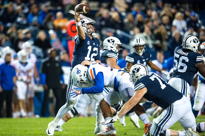 (Chris Detrick  |  The Salt Lake Tribune)  Brigham Young Cougars quarterback Tanner Mangum (12) passes as he is tackled by Boise State Broncos defensive end Curtis Weaver (99) during the game LaVell Edwards Stadium Friday, October 6, 2017. Boise State Broncos defeated Brigham Young Cougars 24-7.