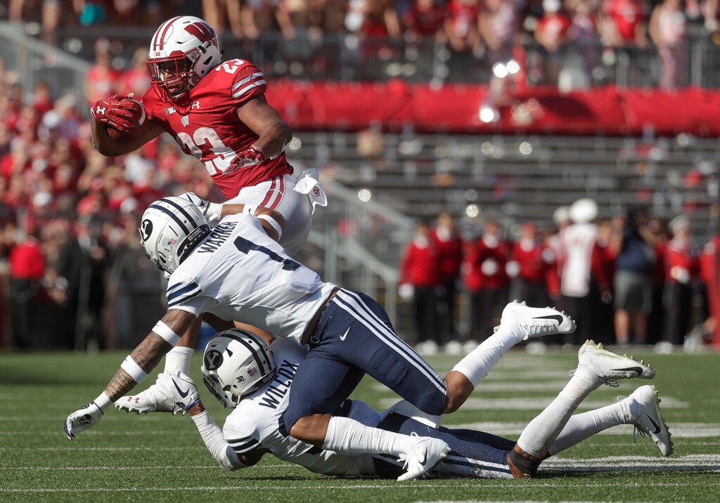 BYU defensive backs Chris Wilcox and Troy Warner (1), shown here tackling Wisconsin's Jonathan Taylor, will try to slow down Washington's prolific passing attack Saturday in Seattle. (AP Photo/Morry Gash)