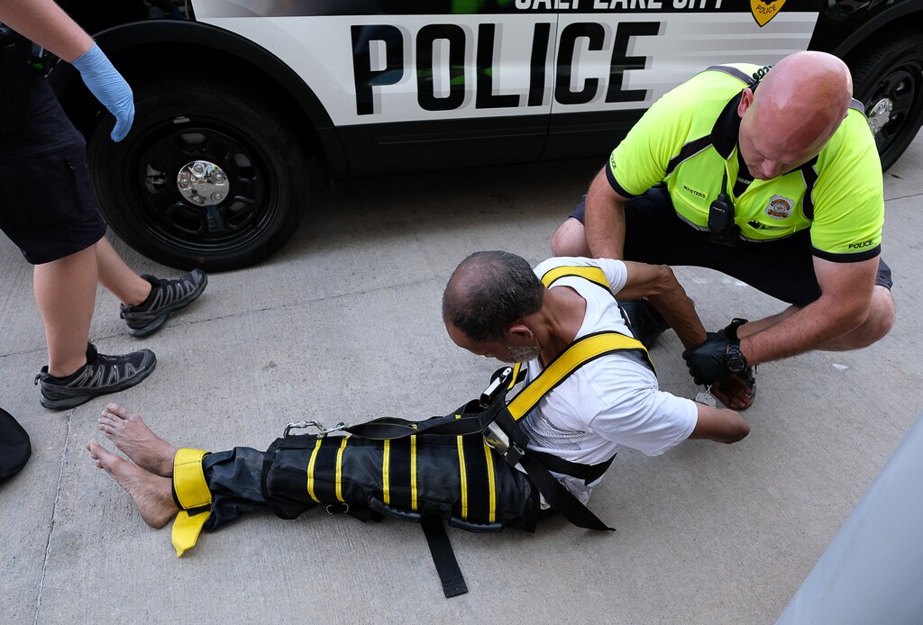 (Francisco Kjolseth  |  The Salt Lake Tribune)  A homeless man, who was reported by a restaurant along North Temple for exposing himself when he urinated in the flowers in front of the business and was eventually arrested, is later restrained with The Wrap when he kept unbuckling his seat belt and placing himself upside down in the back of the patrol car. Members of the west-side policing bicycle squad patrol Glendale and Rose Park with an emphasis along North Temple, where they have seen an increase in criminal activity following Operation Rio Grande, nearing the halfway mark.