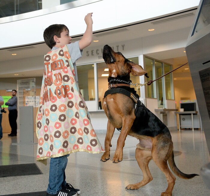 (Al Hartmann  |  The Salt Lake Tribune) 	10-year-old Tyler Carach, " Donut Boy" feeds a sugar free dog snack to "Huckleberry" a K-9 blood hound at the Salt Lake Police Station Monday Oct. 30.   Tyler and his family are visiting police officers in 10 states in 10 days.  Tyler’s mission to recognize and thank police officers around the country began in August 2016 when he offered to purchase two police officers donuts with his own money. To date, Tyler has handed out over 25,000 donuts to police officers throughout the country. 