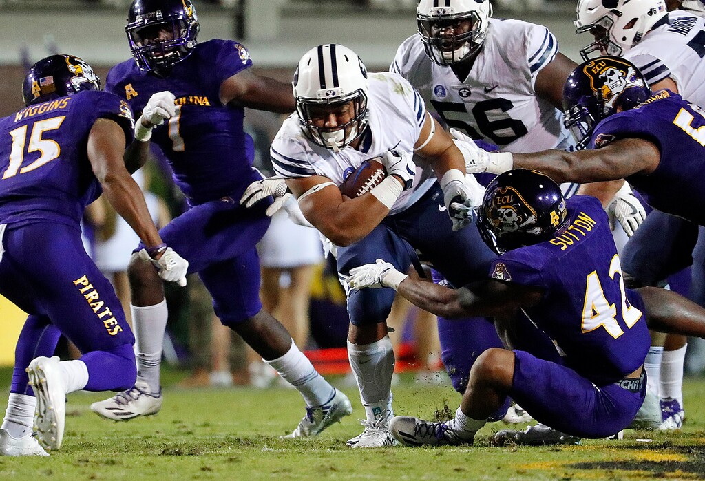 BYU's Ula Tolutau (5) tries to break away from East Carolina's Devon Sutton (42) and others tacklers during the first half of an NCAA college football game in Greenville, N.C., Saturday, Oct. 21, 2017. (AP Photo/Karl B DeBlaker)
