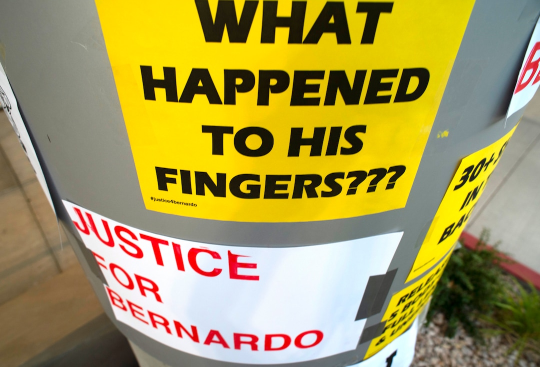 (Rick Egan  |  The Salt Lake Tribune) Protesters tape signs on the Salt Lake District Attorney's office building during a Justice for Bernardo Palacios-Carbajal protest on Tuesday, June 23, 2020.