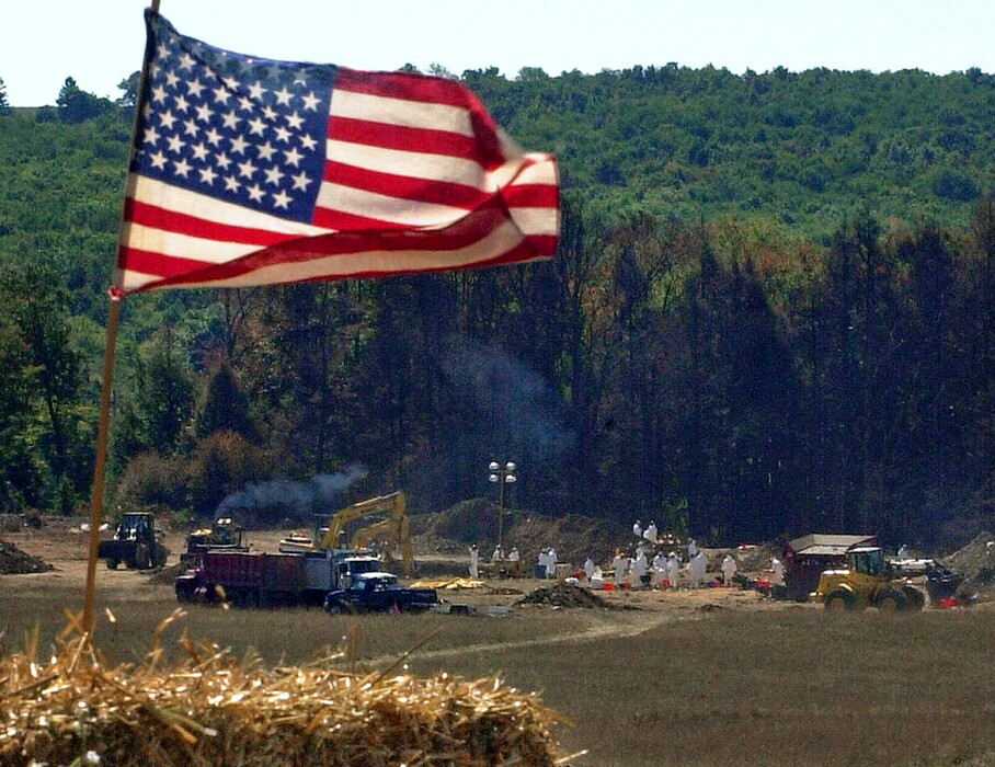FILE – In this Sept. 16, 2001, file photo, an American flag flies from a makeshift altar overlooking the ongoing investigation of the United Flight 93 crash site in Shanksville, Pa. Officials announced Friday, June 1, 2018, that later in the year, the National Park Service will return the remaining wreckage of United Flight 93 to the Pennsylvania memorial marking where it crashed in the 9/11 terror attacks, and the remaining wreckage will be buried in a restricted area accessible only to loved ones of the victims. (AP Photo/Gene J. Puskar, File)